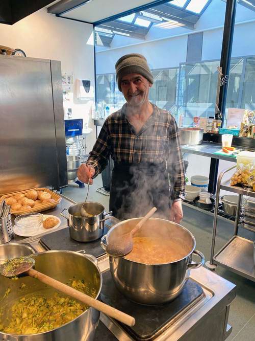 Køkkenmedhjælperen Abdulquadr, som på billedet er ved at tilføje de sidste ingredienser til Linsesuppen, inden den er klar til servering.